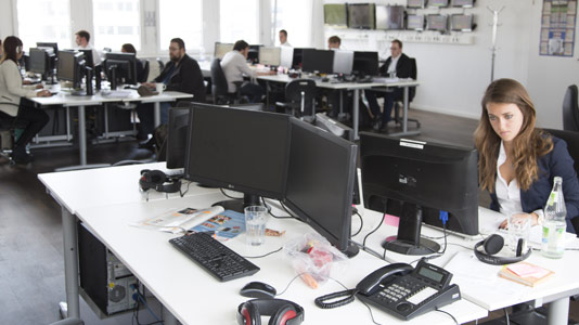 Mitarbeiter von Airmotion Media arbeiten an Schreibtischen mit Bildschirmen